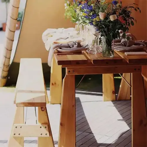 Træbænk ved et rustikt træbord i en tipi