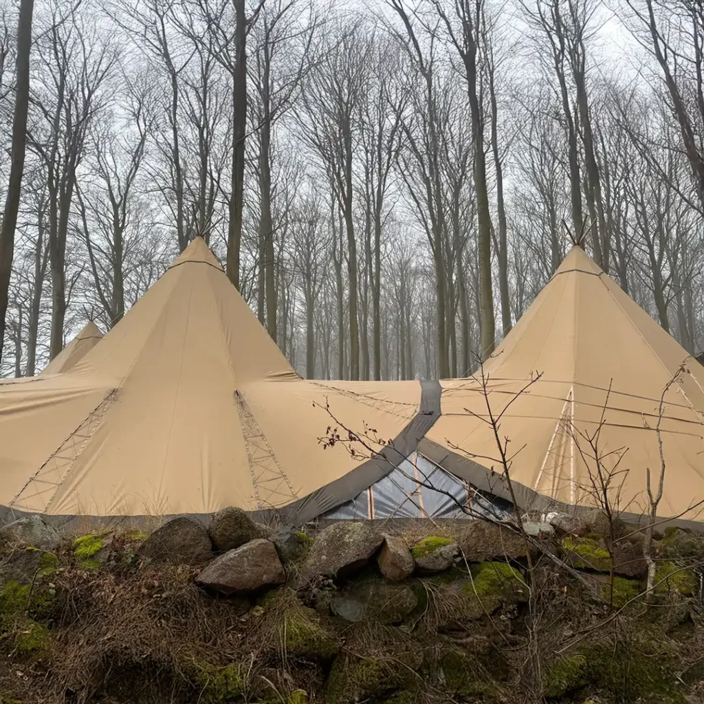 Store, forbundne tipi-telte placeret i en tæt skov på Langeland – ideelle til bryllupper, firmaevents og fester i smukke, naturskønne omgivelser.