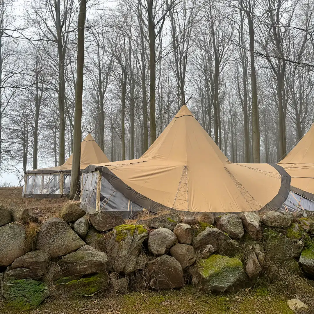 Store tipi-telte placeret i en fredfyldt skov på Langeland, perfekte til unikke naturoplevelser, fester og firmaevents i smukke og rolige omgivelser.