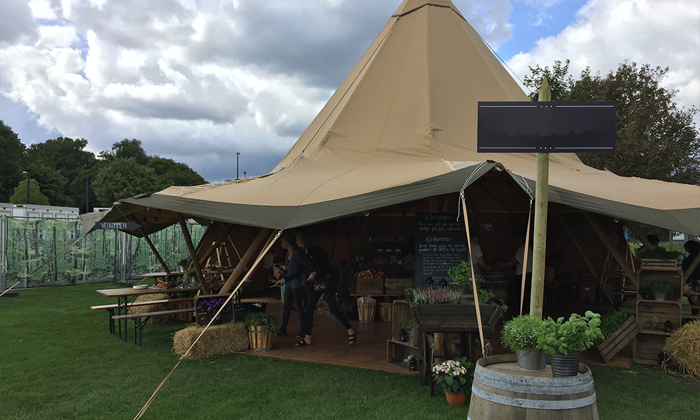 Tipi-telt indrettet som rustik markedsstand med grøntsager, blomster og dekorationer, perfekt til messer og events – TipiogCo