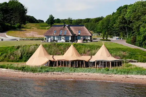 Tipi-telte ved stranden foran en eksklusiv villa, perfekt til events, bryllupper og firmafester i smukke omgivelser med luksusoplevelse – TipiogCo.