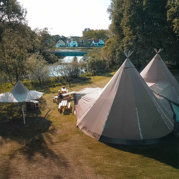 Tipi-telt oplyst med hyggelige lyskæder skaber en magisk stemning til bryllup eller event i naturskønne omgivelser – TipiogCo.