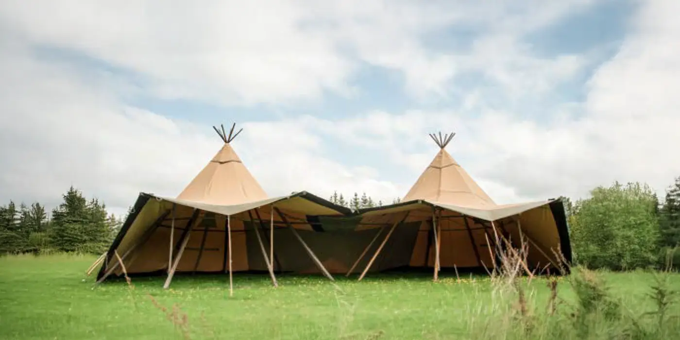 To Stratus 40 tipier forbundet med åbne sider på en grøn eng – viser fleksibel opsætning til events, bryllupper og festivaler.